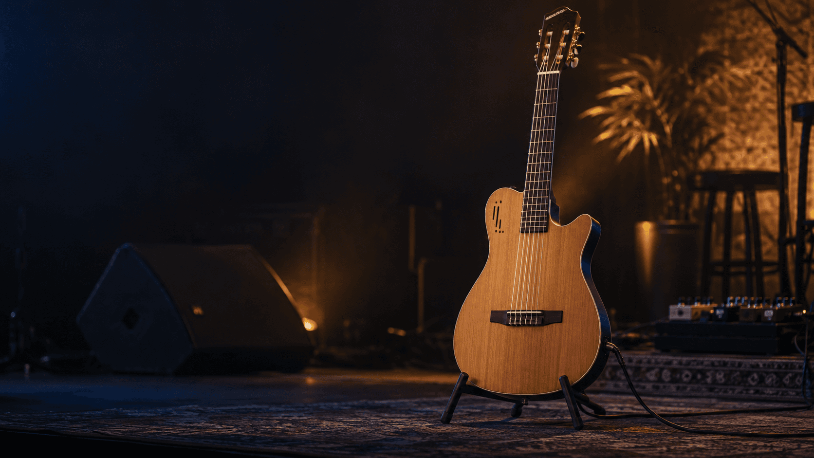 Violão eletroacústico flat de nylon em um pequeno palco, ligado ao sistema de som